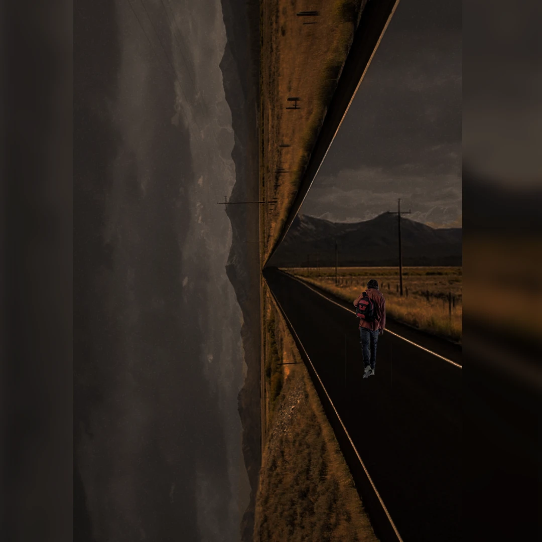 Photo of a man walking down a road at night